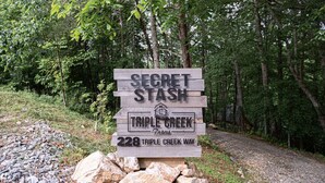 A wooden sign with the text "SECRET STASH" and "TRIPLE CREEK Farms" along with an address "228 TRIPLE CREEK WAY". - Secret Stash: Secluded Treehouse Overlooking Creek (Dahlonega)