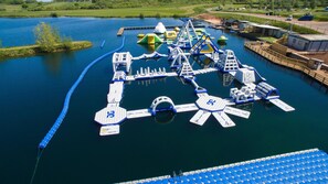 Luchtbeeld van een waterpark met diverse waterattracties en een pier.