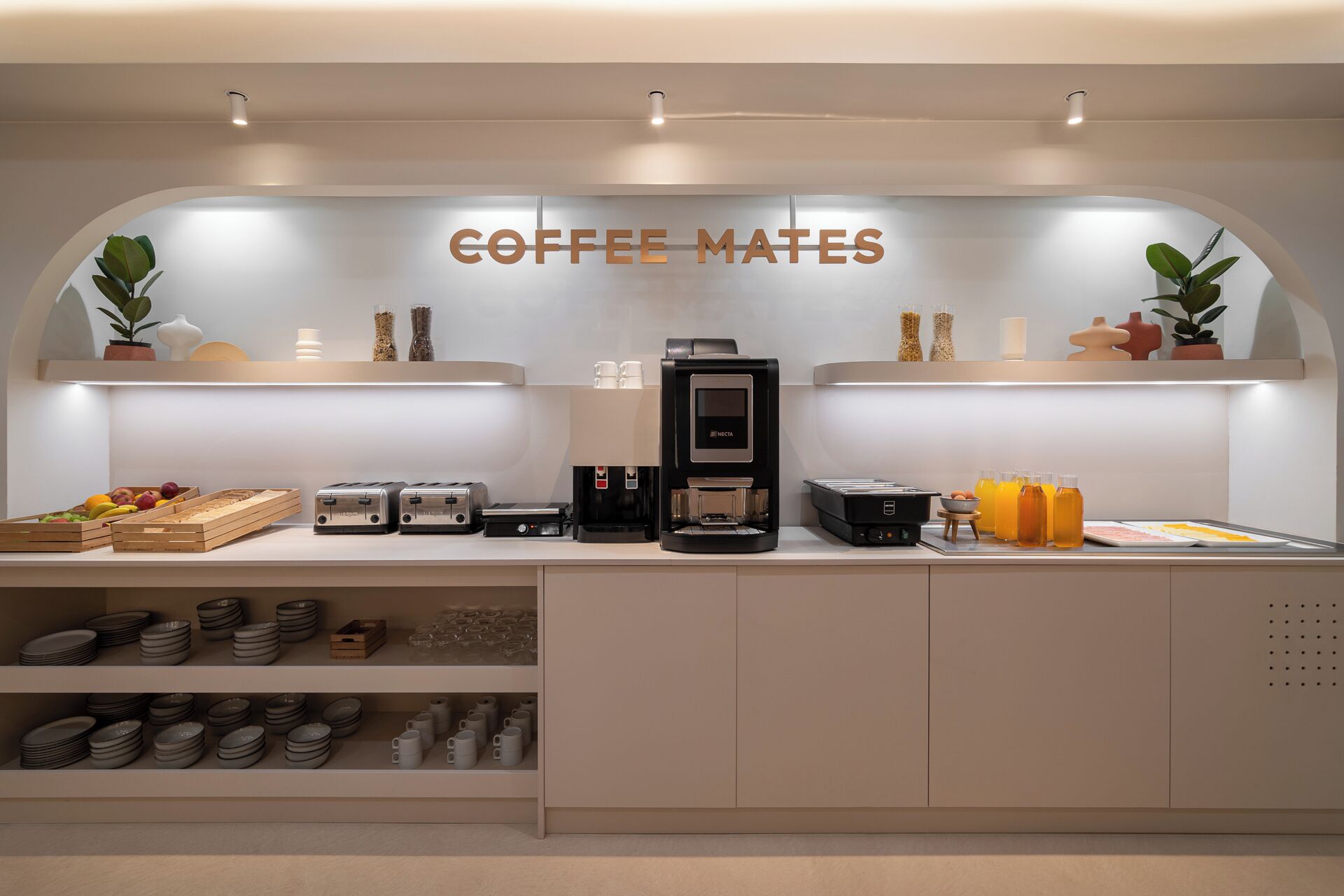 Eine Kaffeestation mit Kaffeemaschine, Toastern sowie verschiedenen Tassen und Bechern.