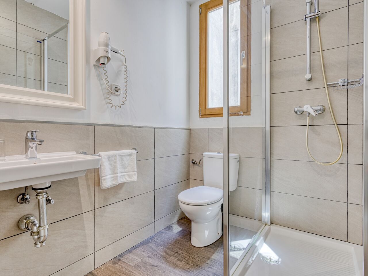 A bathroom with a toilet, sink, and shower.