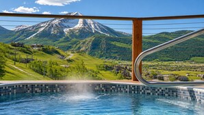 A swimming pool with a mountain view, wooden deck, and metal railing. - Mountain Views, Hot Tub & Walk to Summer Concerts (Crested Butte)