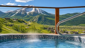 A swimming pool with a mountain view, wooden deck, and metal railing. - Mountain Views, Hot Tub & Walk to Summer Concerts (Crested Butte)
