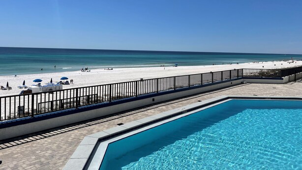 Una piscina con vista a una playa y al océano.