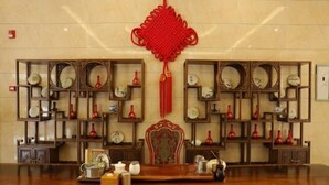 A traditional interior with a central ornate chair, surrounded by shelves with clocks and vases. - Impression Hotel (Wenshan City)