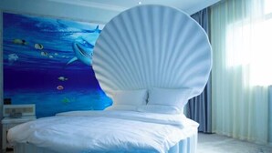A modern bedroom with a unique bed design, a mural of an underwater scene, and a large window with curtains. - Impression Hotel (Wenshan City)