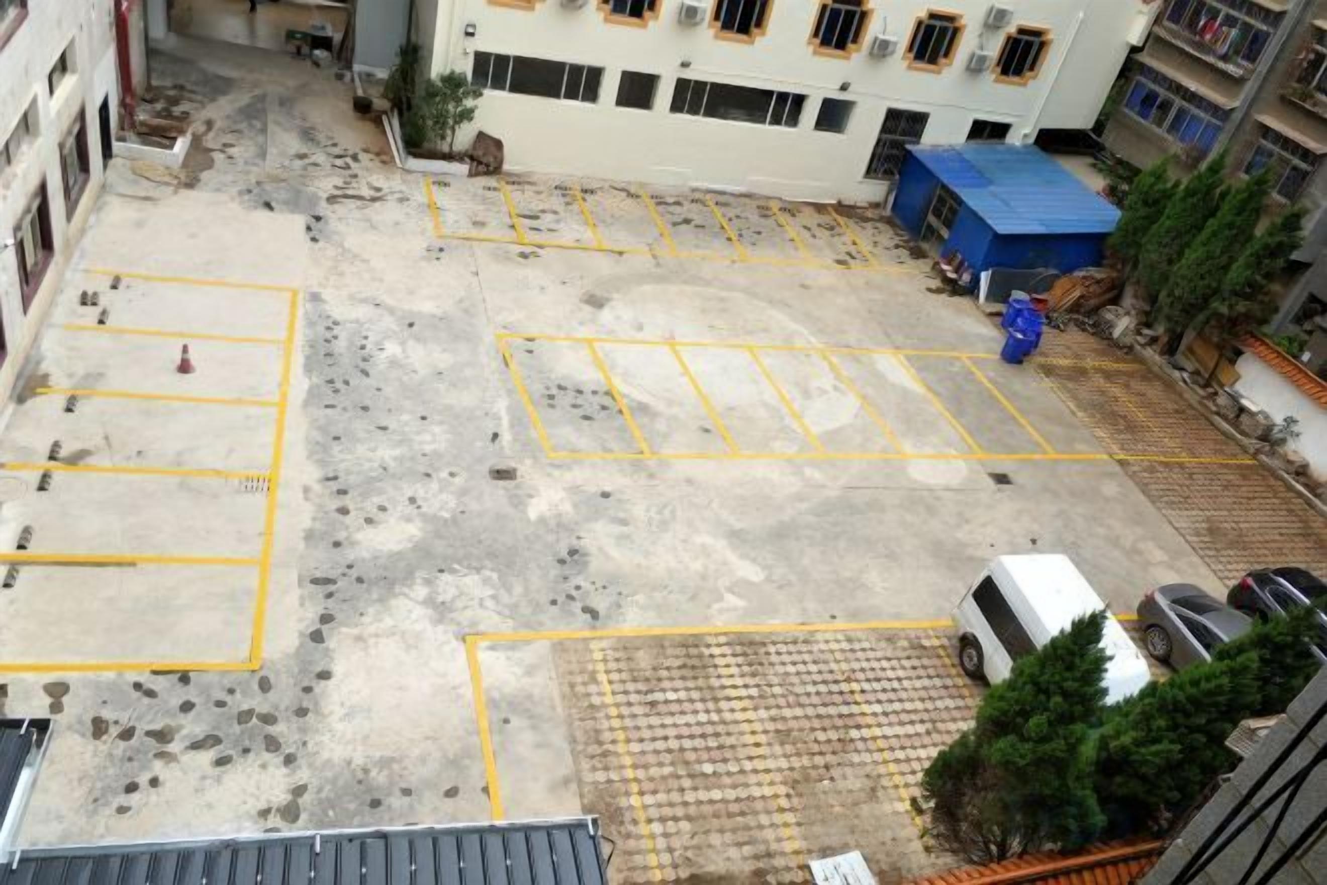 Un estacionamiento con espacios delimitados y una carpa azul.