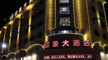 A hotel with illuminated signage, multiple floors, and a prominent entrance.