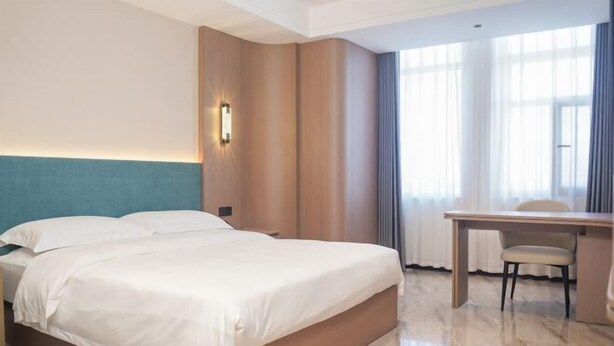 A hotel room with a bed, a desk, and a chair. - Kangtai Hotel (Hanggin Banner)