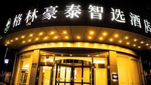 A hotel entrance with illuminated signage and a revolving door. - GreenTree Inn Smart Choice Hotel (Changzhou Xixiashu Branch) (Huludao)