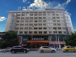 Un hotel de varios pisos con fachada curva, destacándose un cartel en la parte superior.