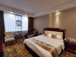 Habitación de hotel con una cama grande, un escritorio, una silla, una ventana con cortinas y vistas a la ciudad.