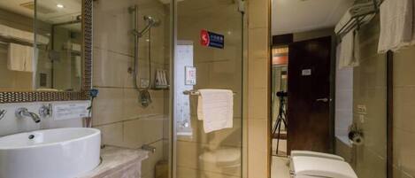 Un baño moderno con ducha de vidrio, lavamanos e inodoro.