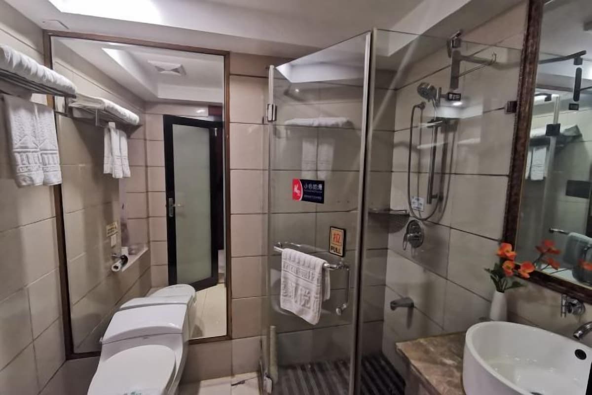 Une salle de bain moderne équipée de toilettes, d’une douche et d’un lavabo.