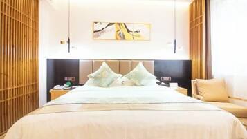 Una habitación de hotel con una cama grande, un cabecero, una mesita de noche, una silla y una obra de arte colgada en la pared.