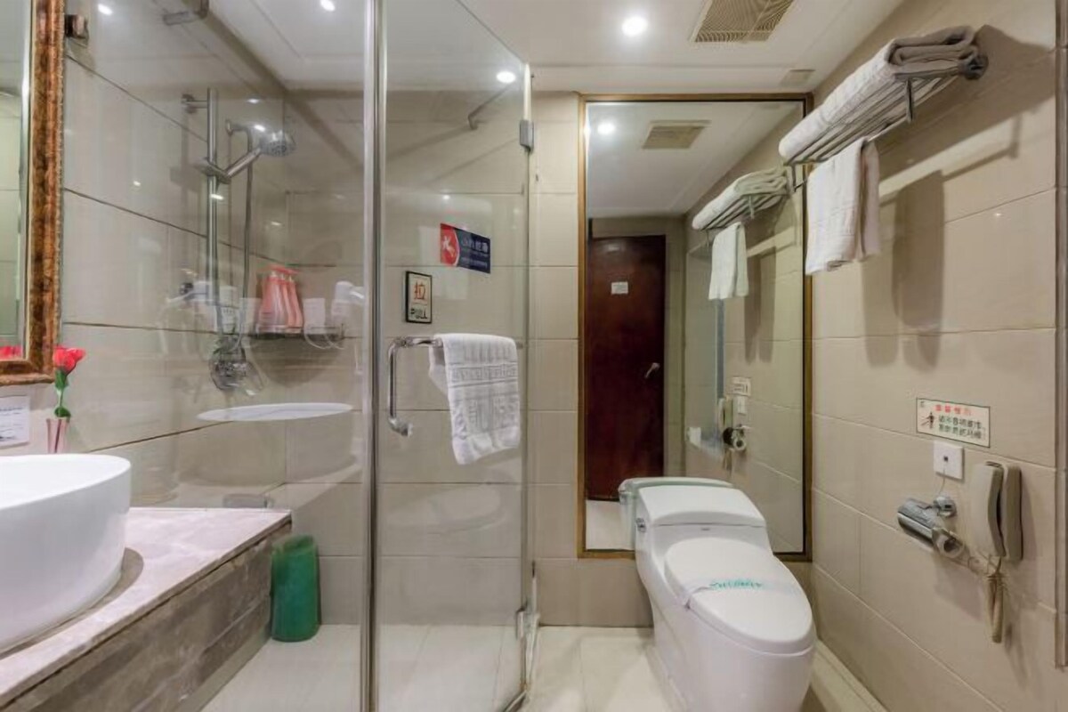 Ein modernes Badezimmer mit einer Glasdusche, einer Toilette und einem Waschbecken.