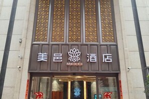 L’entrée d’un hôtel au design traditionnel, avec un logo bien visible et une façade décorative.