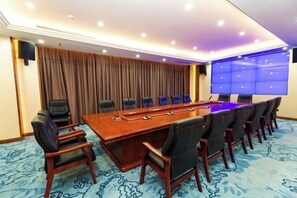 A conference room with a long table, multiple chairs, a large screen, and a blue carpet. - Mei YI Hotel (Yiliang)