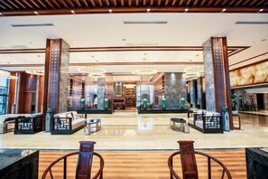 A spacious lobby with a central seating area, a reception desk, and a large mirror reflecting the space. - Mei YI Hotel (Yiliang)