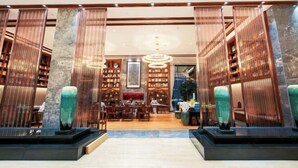 A lobby with a central seating area, bookshelves, and decorative vases. - Mei YI Hotel (Yiliang)