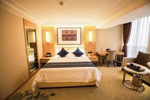 A hotel room with a bed, bedside tables, a desk, a chair, and a sofa. - Mei YI Hotel (Yiliang)
