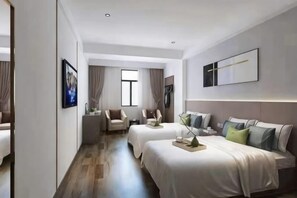 A hotel room with two beds, a desk, a chair, a TV, and a window.