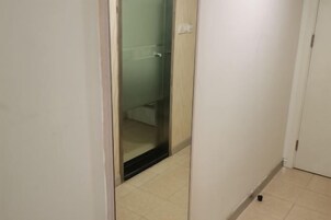 Un pasillo estrecho con una puerta de cristal que da al baño.