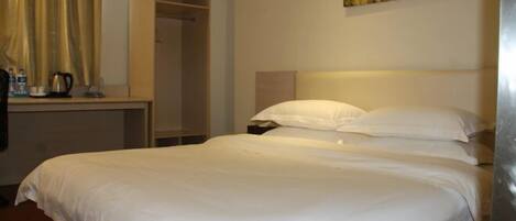 Una cama bien tendida con sábanas blancas en una habitación de hotel.