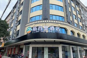 Un hotel con fachada curva, amplias ventanas y un cartel que indica que se trata del New Silas Hotel.