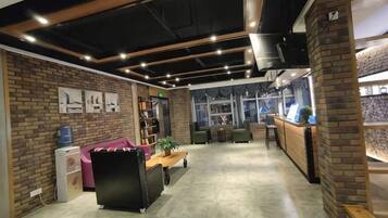 A modern interior with a brick wall, a reception desk, and a seating area with a sofa and chairs.