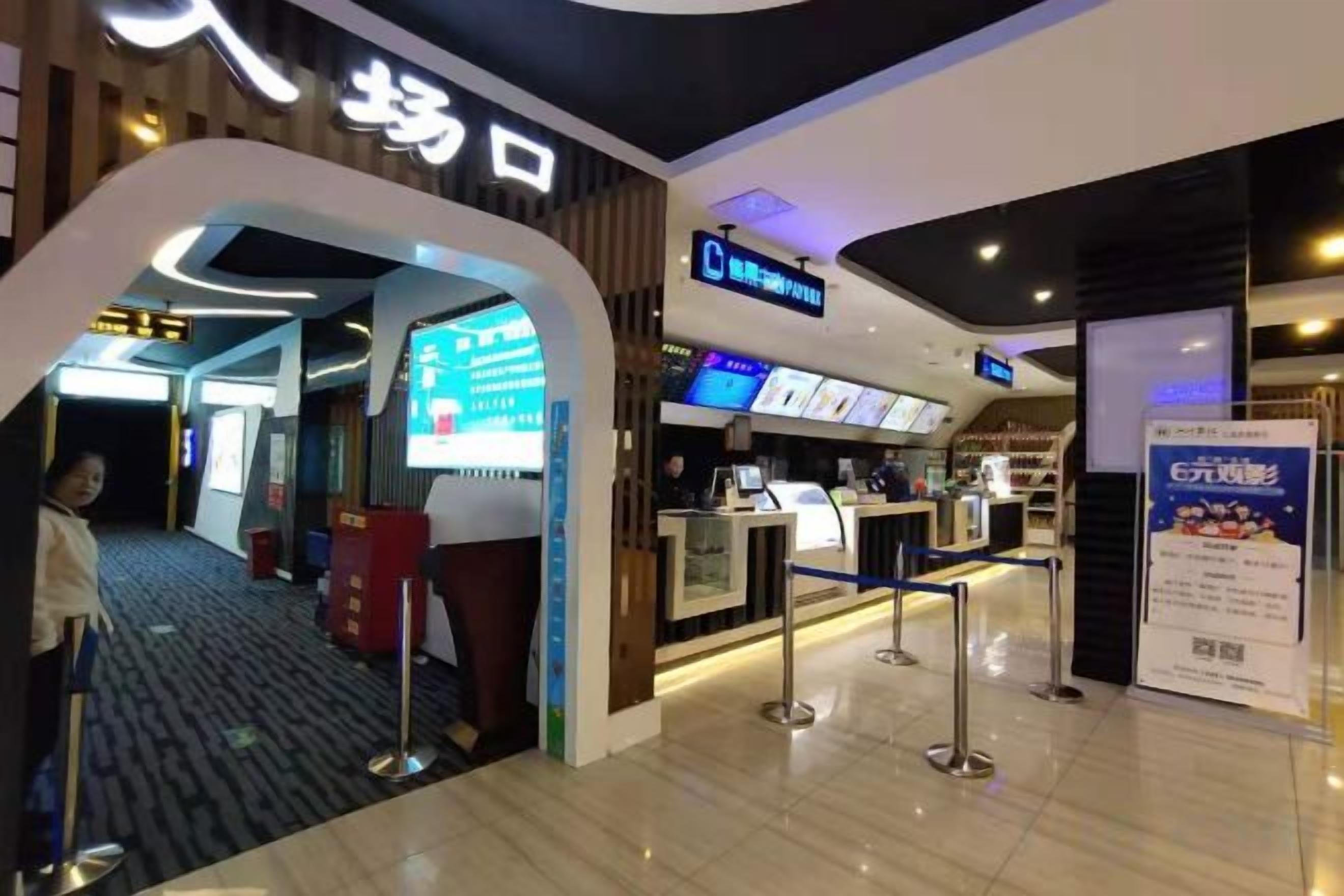 A hotel entrance with a reception desk, a digital directory, and a signboard.