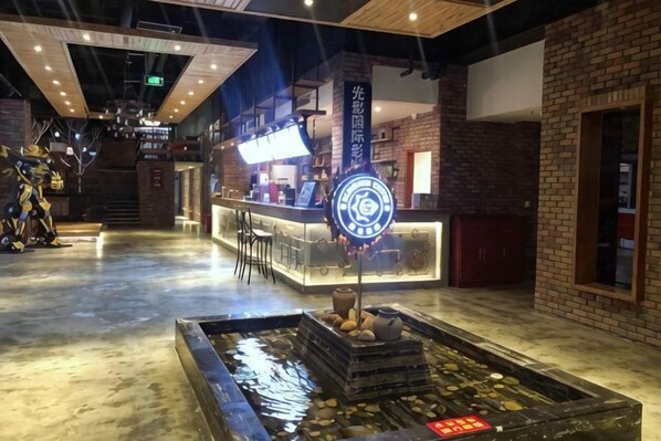 A bar area with a counter, stools, and a decorative water feature.
