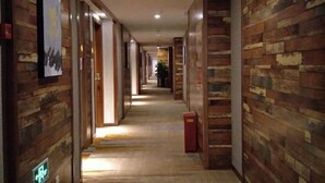 A long, narrow hallway with wooden paneling on the walls and a tiled floor. - Renshou Wanye Sunshine Hotel (Renshou)