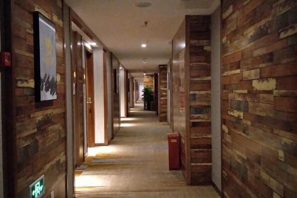 A long, narrow hallway with wooden paneling on the walls and a tiled floor. - Renshou Wanye Sunshine Hotel (Renshou)