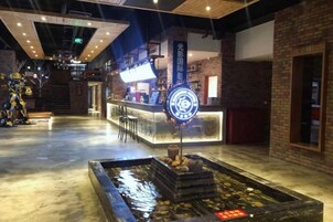 A bar area with a counter, stools, and a decorative water feature.