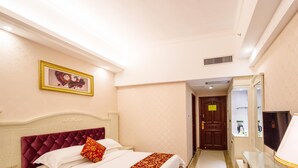 Una habitación de hotel con cama, mesita de noche, lámpara y espejo.