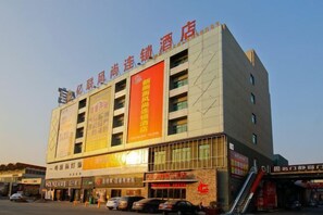 Un hôtel à plusieurs étages, dont la façade est ornée d’une grande enseigne rouge.