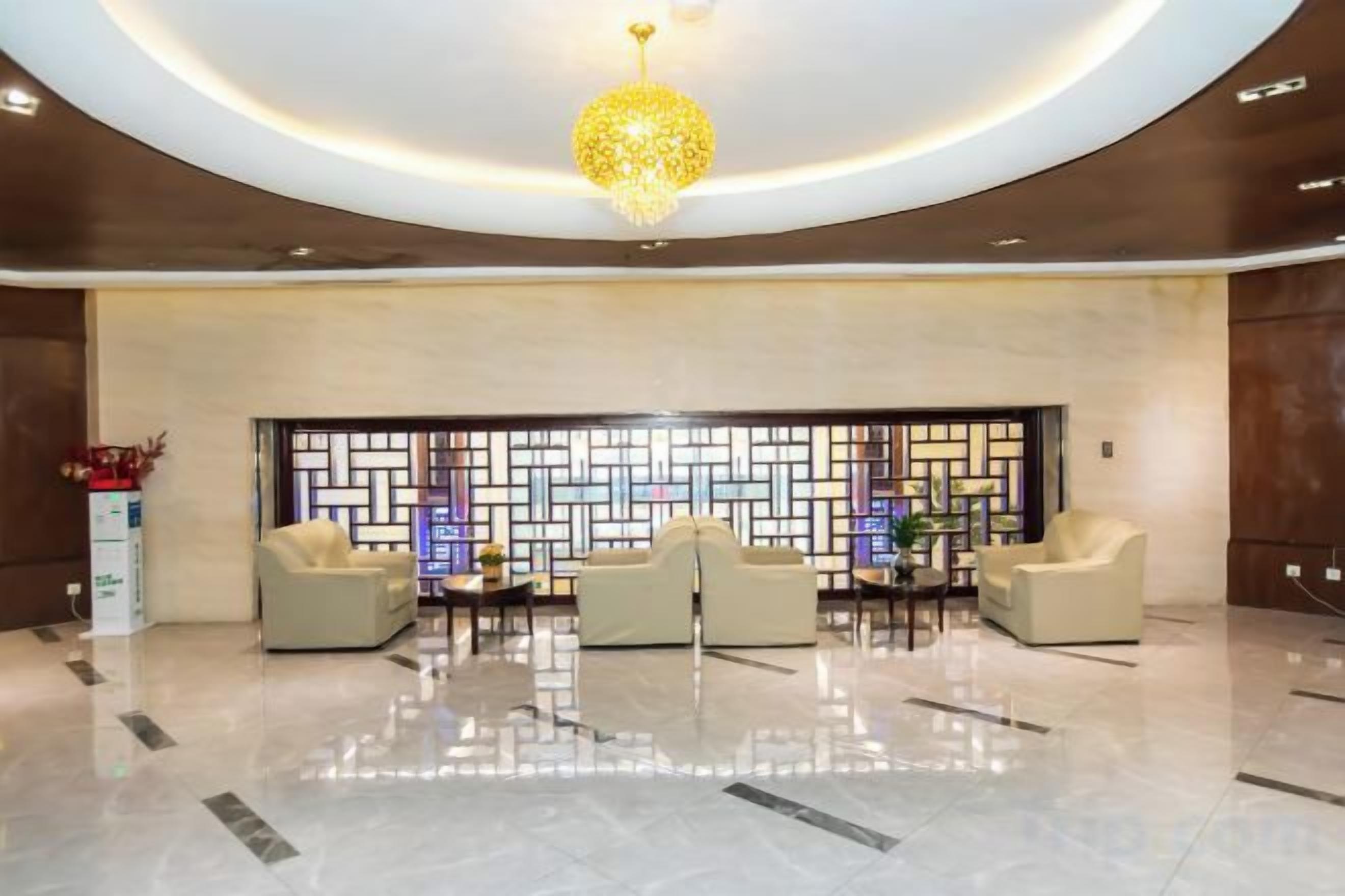 A lobby with a reception desk, seating area, and a decorative wall.