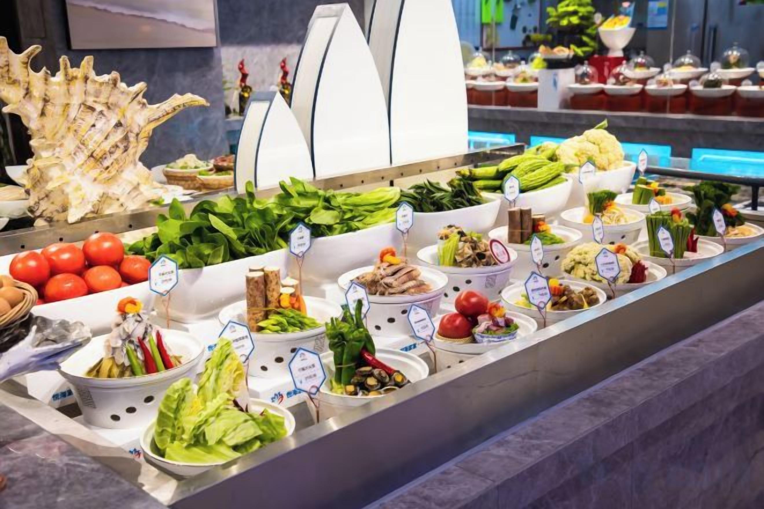 A buffet with various food items and a large decorative shell.