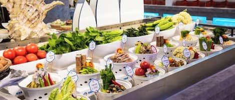 A buffet with various food items and a large decorative shell.