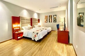 A hotel room with a large bed, bedside tables, a desk, and a mirror. - Sea Party Hotel (Laixi)