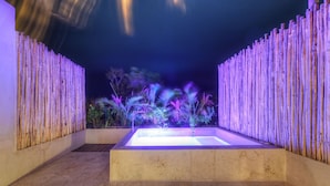 A spa area with a rectangular pool, surrounded by a bamboo fence, and a variety of tropical plants. - Eco-chic Design Condos Wrapped in Nature's Elements (Tulum)