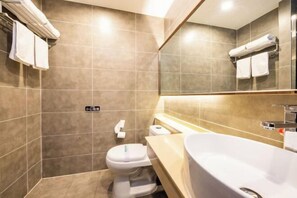 A modern bathroom with a large sink, a toilet, and a mirror. - Yasheng Hotel (Taicang Port Area) (Taicang)