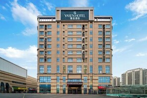 A multi-story hotel building with a prominent signage at the top. - Yasheng Hotel (Taicang Port Area) (Taicang)