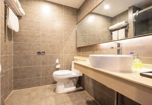 A modern bathroom with a toilet, sink, and mirror. - Yasheng Hotel (Taicang Port Area) (Taicang)