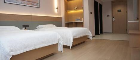 Habitación de hotel con dos camas, estante empotrado con artículos de aseo y un cuadro en la pared.