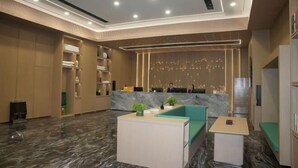 A modern hotel lobby with a marble floor, a reception desk, seating areas, and a decorative wall with lights. - Star Sky Hotel (Fu County)
