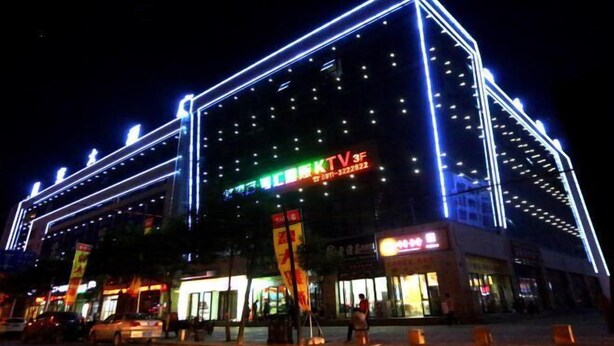 A brightly lit building with neon signage, including a prominent TV3 logo. - Star Sky Hotel (Fu County)