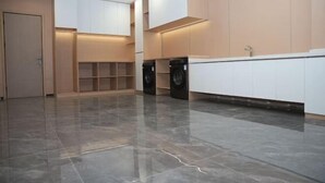A modern kitchen with built-in appliances, a large countertop, and a tiled floor. - Star Sky Hotel (Fu County)