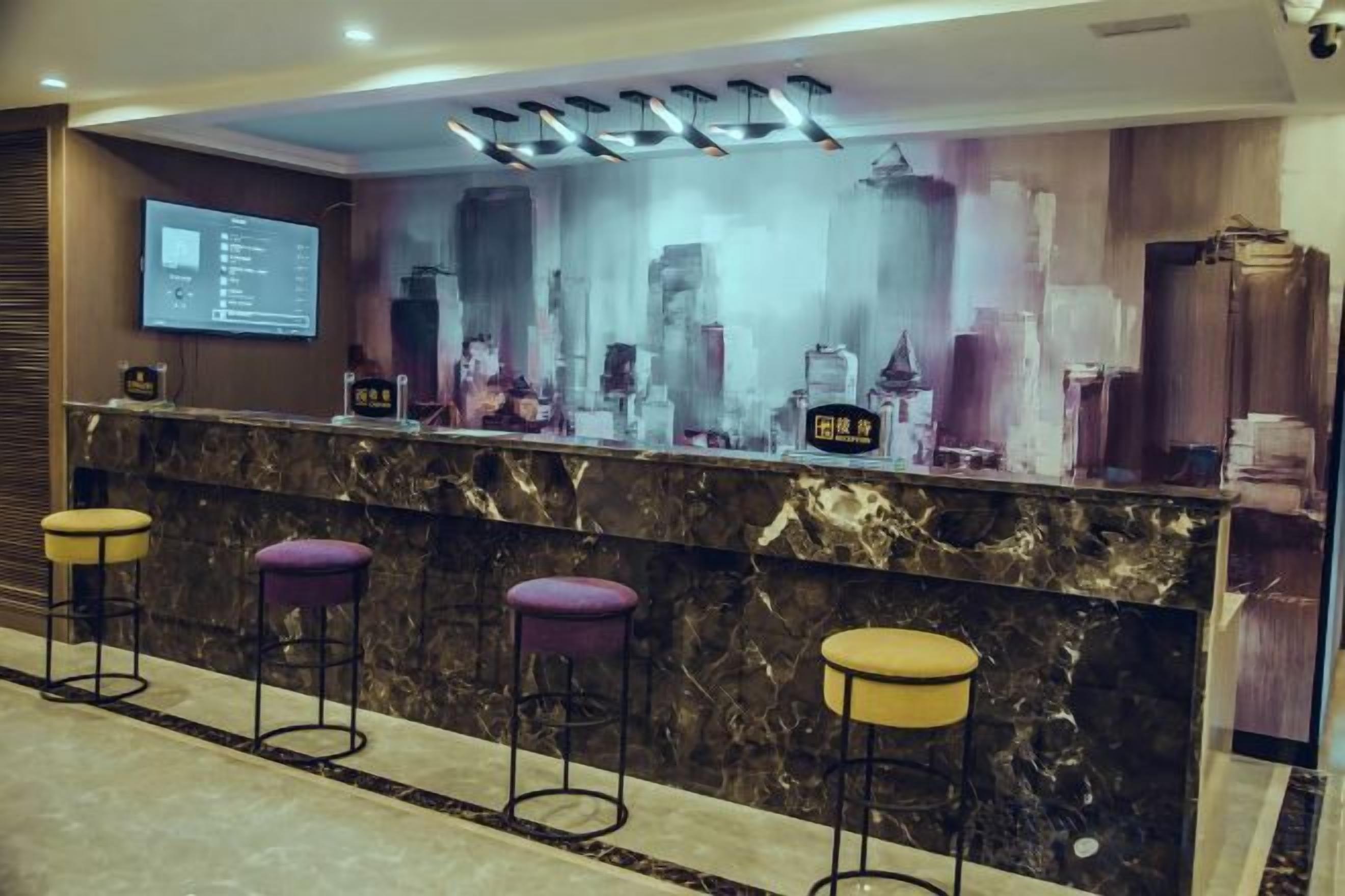 A bar area with a marble countertop, purple stools, and a cityscape mural.