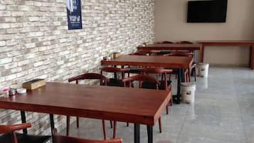 Un restaurante con paredes de ladrillo, mesas y sillas de madera.